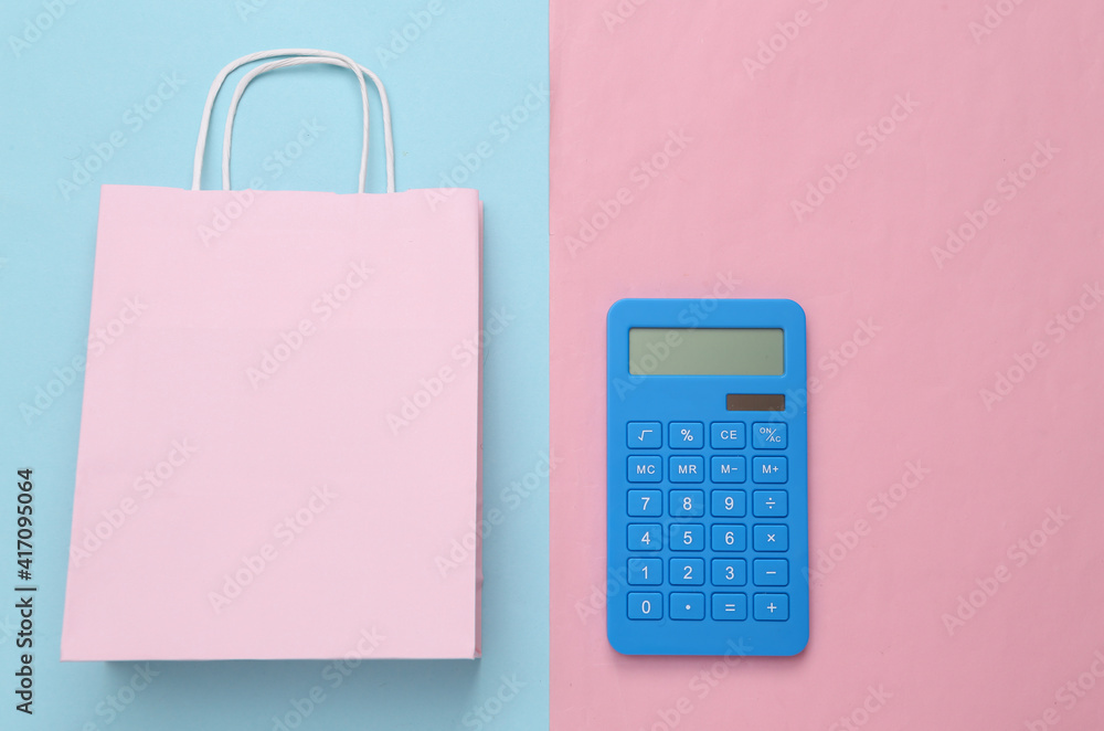 Sale concept. Shopping bag with calculator on pink blue background. Top view Sale concept. Shopping bag with calculator on pink blue background. Top view