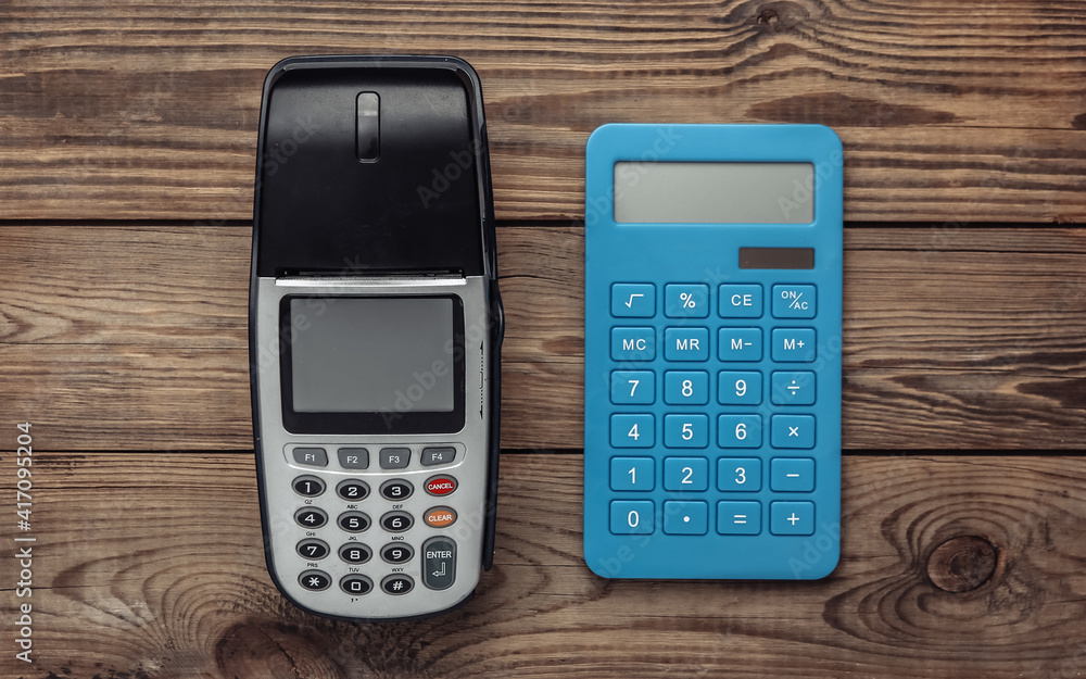 Payment POS terminal and calculatror on wooden table. Top view Payment POS terminal and calculatror on wooden table. Top view