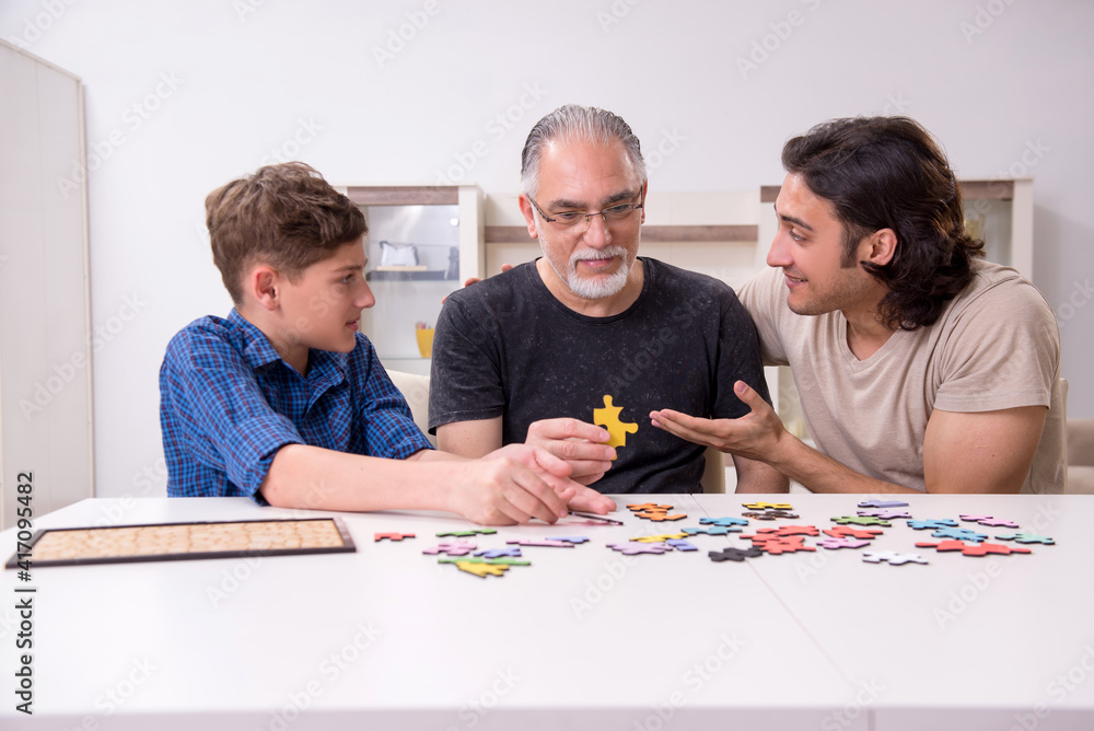 Three generations of family playing jigsaw puzzle game Three generations of family playing jigsaw puzzle game