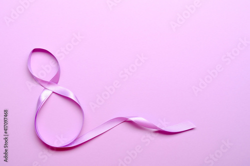 Purple gift celebration ribbon in 8 namber over purple background. 8 march