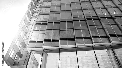 Downtown corporate business district architecture. Glass reflective office buildings against  sky. Economy  finances  business activity concept. Rising sun on the horizon. Black and white.