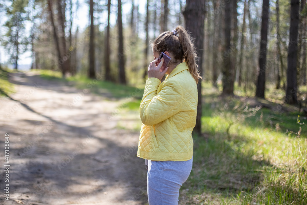 woman in the forest is emotionally talking on the phone. 5g cellular communication concept