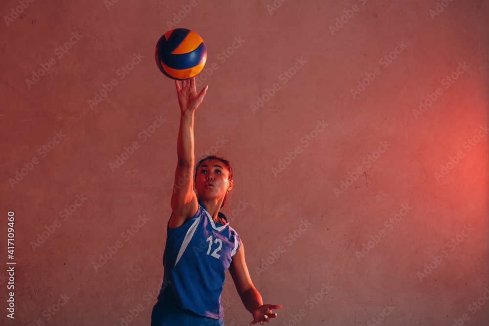 Young asian woman smiling volleyball player with ball