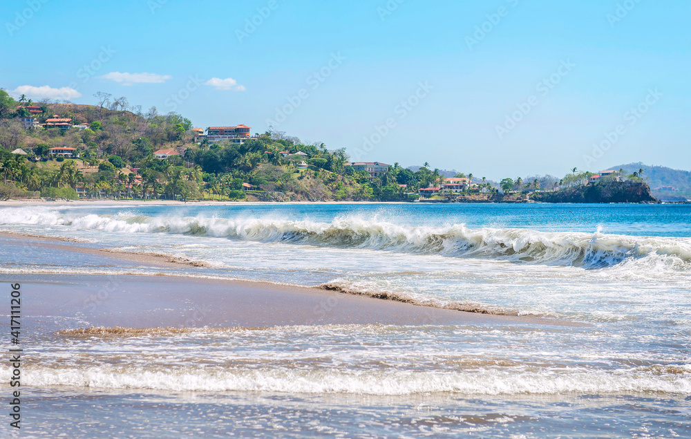 White Beach at Playa Flamingo with blue ocean and big waves. Guanacaste, Costa Rica, Central America.
