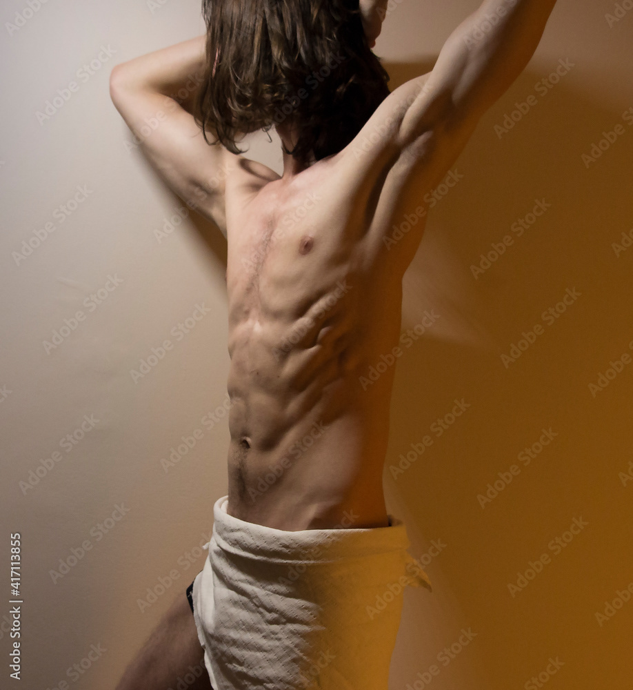 Defined long hair male model standing in dramatic light, abdominal muscles and obliquies reference Defined long hair male model standing in dramatic light, abdominal muscles and obliquies reference