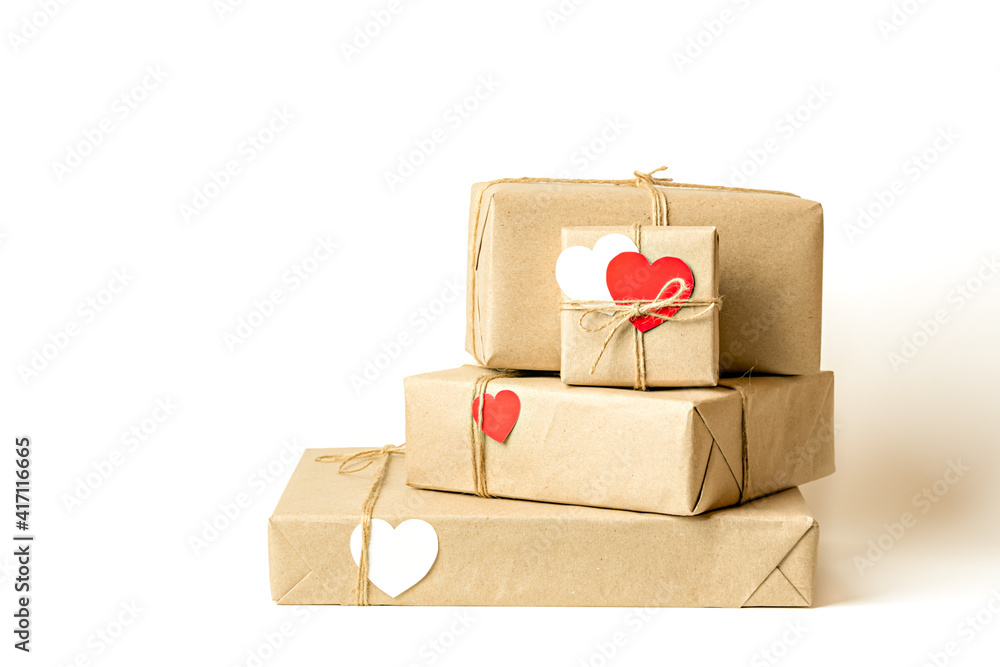Obraz premium Gift boxes wrapped in recycled craft paper tied with twine on white background