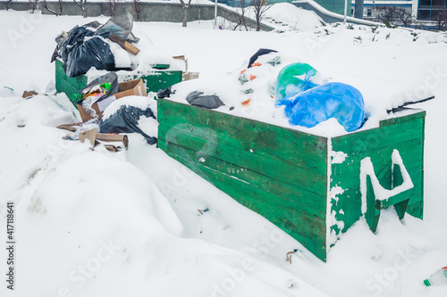 Photography Garbage in the snow and in green wooden boxes on the city street