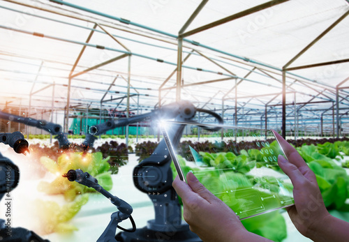 Canvastavla Farmers use futuristic tablet to inspect robotic arm harvest produce and monitor agricultural product vegetable farm,concept technology agriculture industry 4