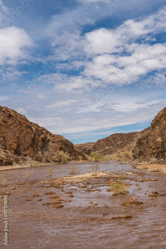 Gaub river in Namibia with much water after heavy rainfalls, Namib Naukluft Park, background cloudy sky