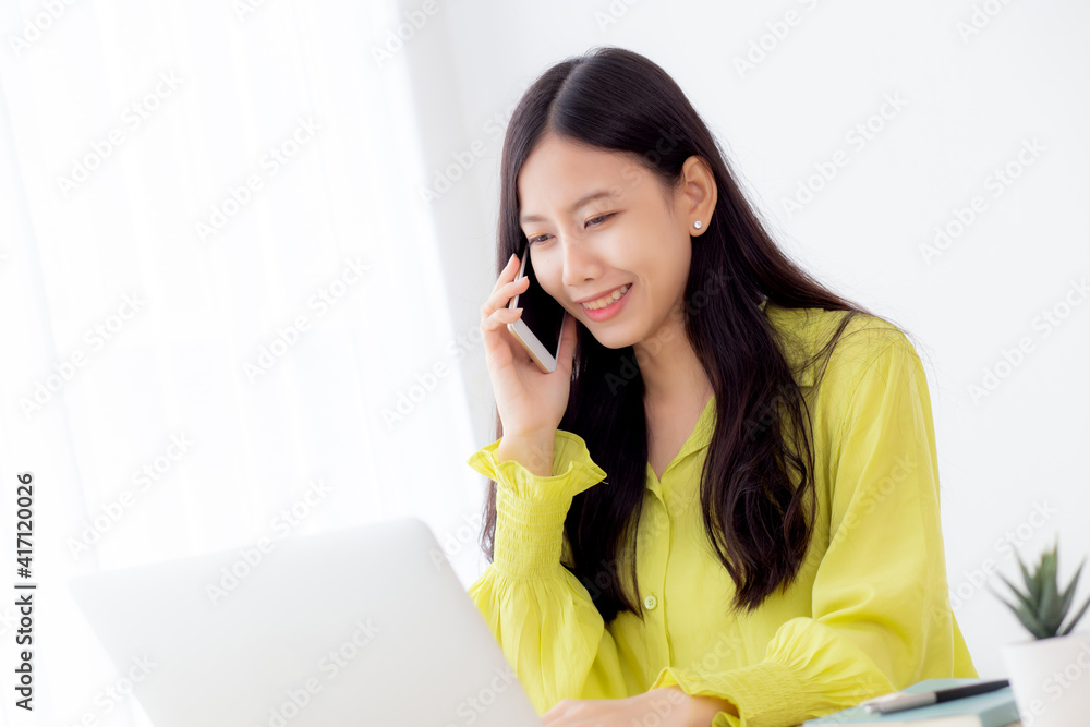 Young asian business woman working form home office and call phone for success at home, businesswoman using laptop computer on desk, female talking smartphone at workplace, communication concept. Young asian business woman working form home office and call phone for success at home, businesswoman using laptop computer on desk, female talking smartphone at workplace, communication concept.