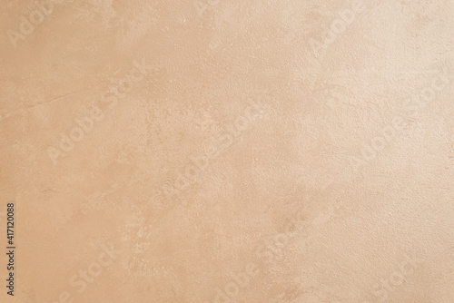 walls are decorated with Venetian decorative plaster with a golden tint of paint. Background, abstraction. The concept of apartment renovation. copy space