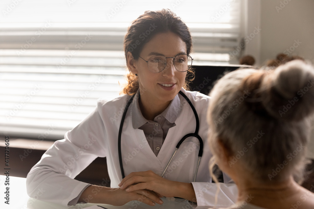 Close up smiling female doctor physician wearing glasses consulting mature patient during appointment in hospital, listening complaints, discussing medical checkup results, health insurance concept Close up smiling female doctor physician wearing glasses consulting mature patient during appointment in hospital, listening complaints, discussing medical checkup results, health insurance concept