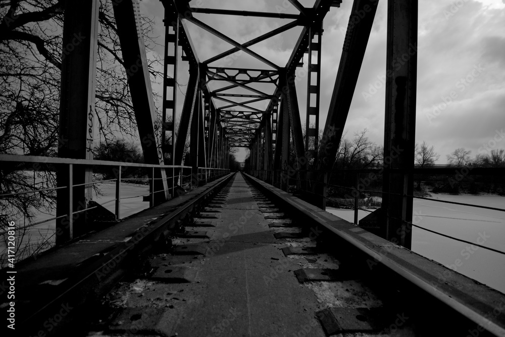 Fototapeta premium an abandoned railway bridge over a frozen river