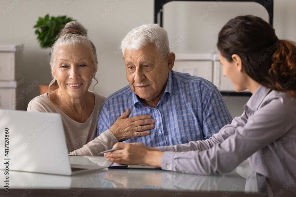 Close up female realtor manager real estate agent consulting mature couple about mortgage or rent, looking at laptop screen, senior family wife and husband listening to financial advisor broker Close up female realtor manager real estate agent consulting mature couple about mortgage or rent, looking at laptop screen, senior family wife and husband listening to financial advisor broker