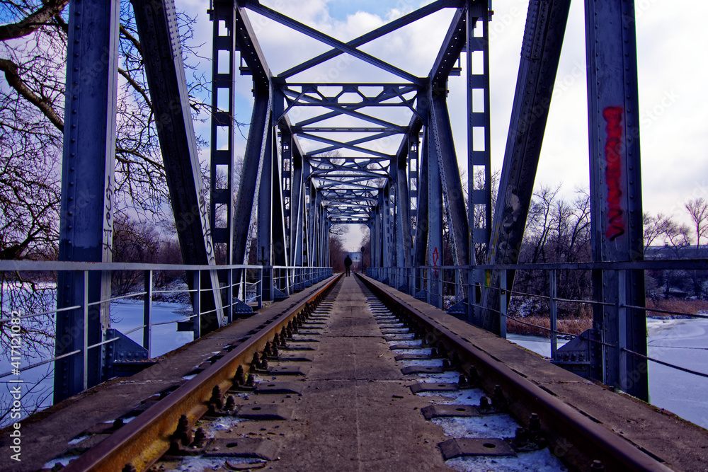 an abandoned railway bridge over a frozen river