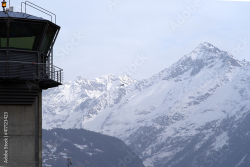 Canvas Print Flight control tower of military airbase with snow mountain panorama in the background