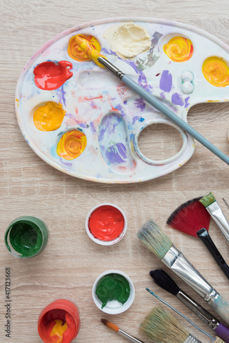 Background, texture. Top view of the artist's easel, gouache and brushes