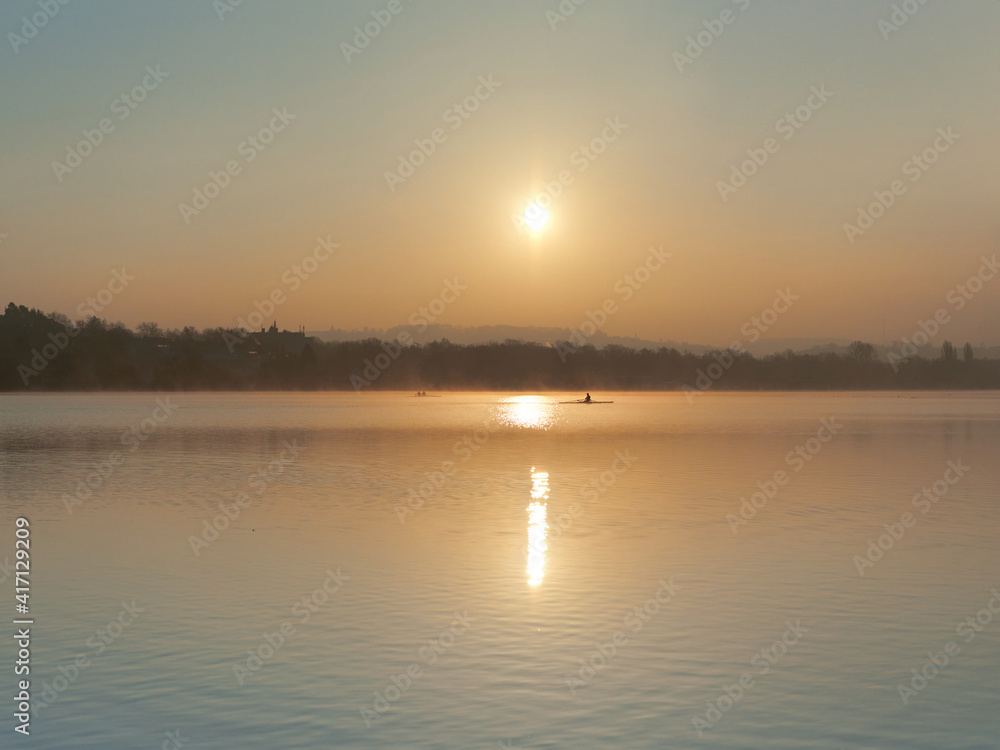The beautiful landscape of Lake Baldeneysee just after sunrise with the rowers in the background. The beautiful landscape of Lake Baldeneysee just after sunrise with the rowers in the background.