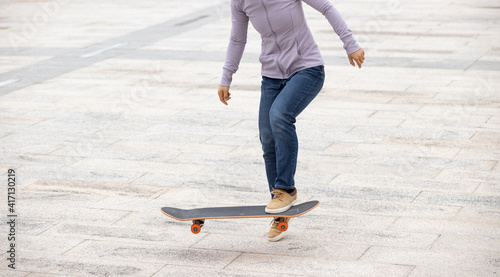 Asian woman skateboarder skateboarding in modern city