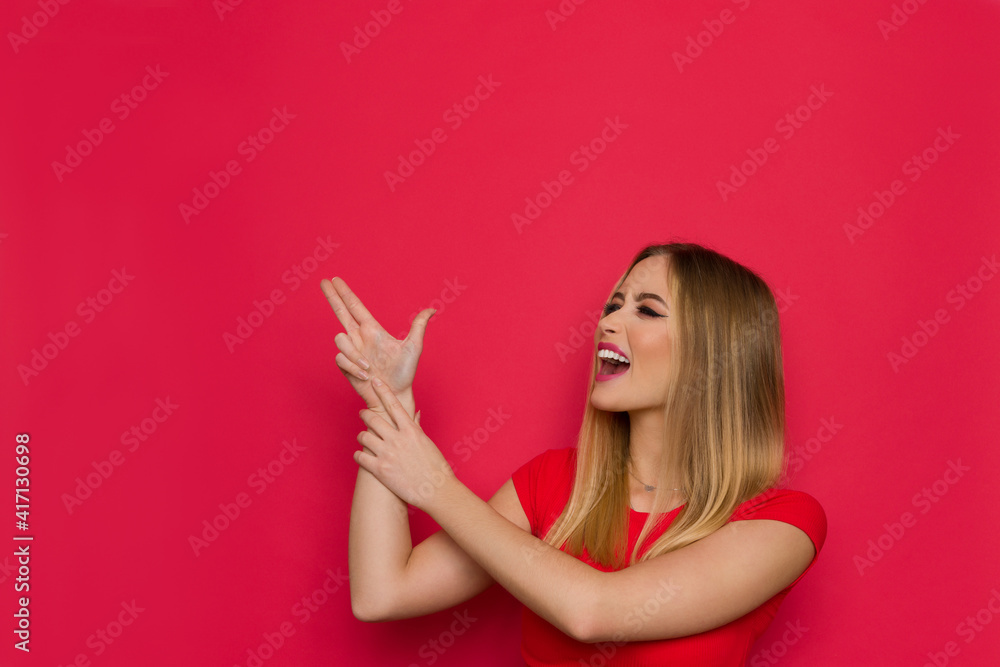 Excited Young Woman Is Aiming With Two Fingers At Red Copy Space And Shouting Excited Young Woman Is Aiming With Two Fingers At Red Copy Space And Shouting