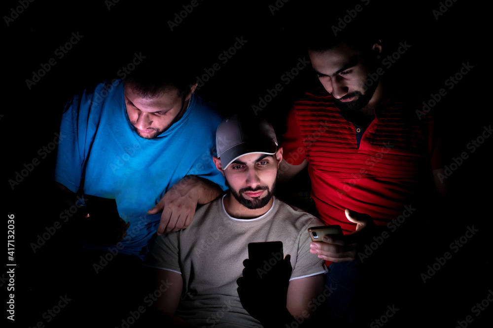 portrait of middle eastern guys setting together in a dark room portrait of middle eastern guys setting together in a dark room