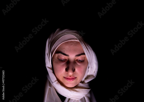Portrait of middle eastern girl checking her phone in a dark room