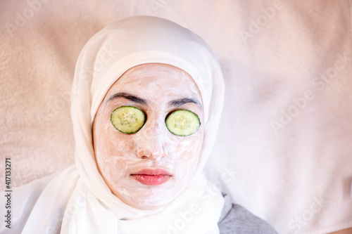 Muslim woman laying down in a spa with facial mask