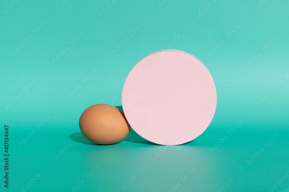 brown natural egg with a pastel pink circle on a mint green background brown natural egg with a pastel pink circle on a mint green background