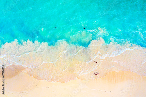 Vacation travel background. Top view aerial drone photo of ocean seashore with beautiful turquoise water and foam sea waves. Caribbean resort. © Nikolay N. Antonov