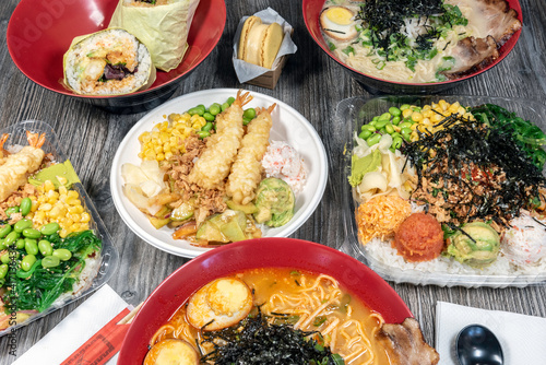 Small bowl of poke topped with shrimp tempura, crab meat, edemame, and corn served up and ready to eat. photo