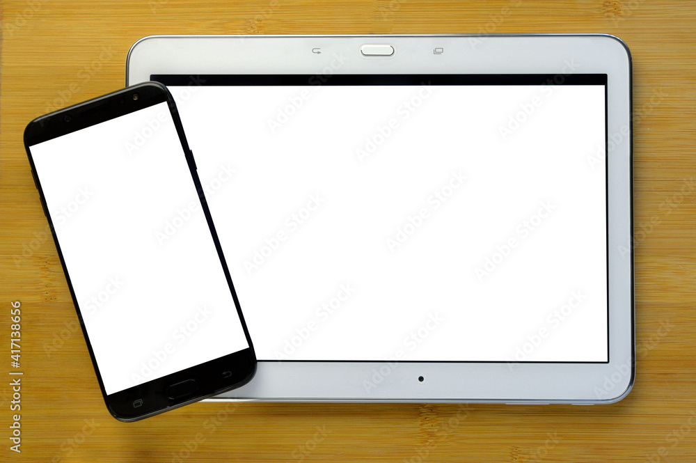 mocap: a black phone lies on a white tablet. wooden background. view from above. mocap: a black phone lies on a white tablet. wooden background. view from above.