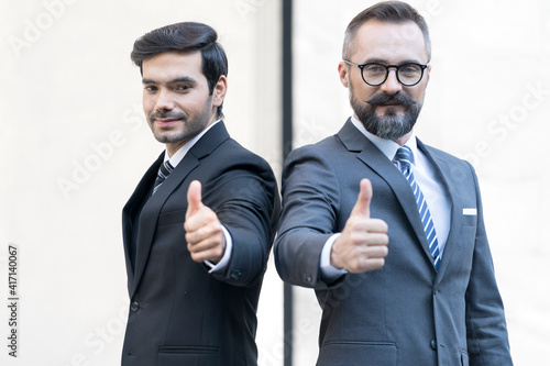 Two business men rejoicing for their success. Businessman show thump up