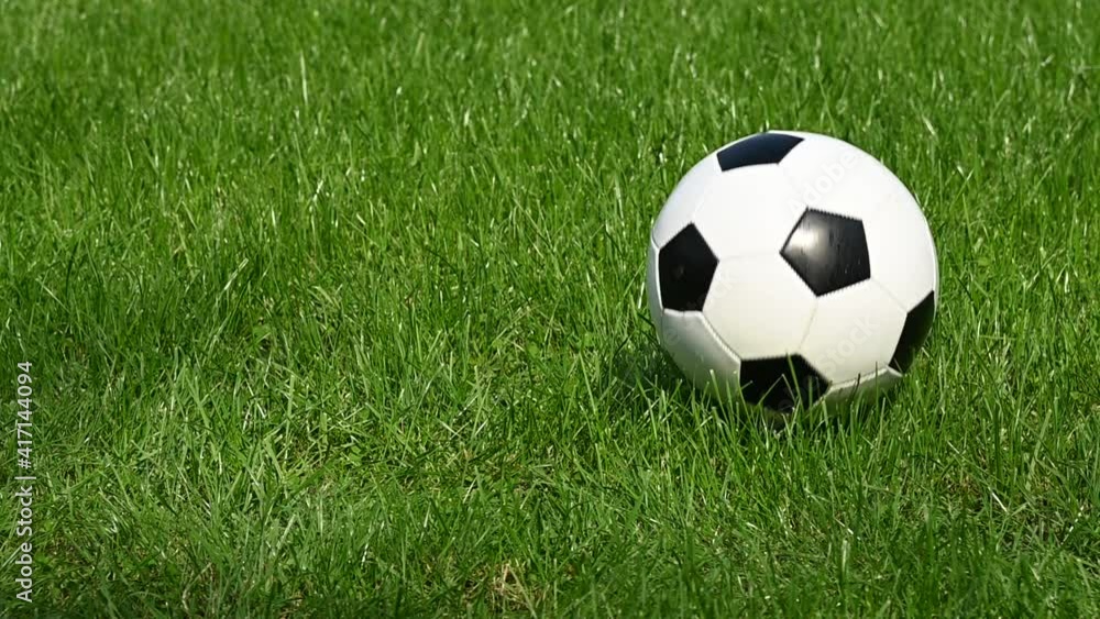 Football ball bouncing on green grass field Football ball bouncing on green grass field