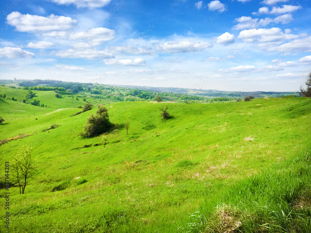Picturesque hilly landscape with bright blue cloudy sky