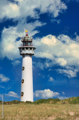 white lighthouse in Egmond aan Zee in the Netherlands, vertical color photo in the summertime