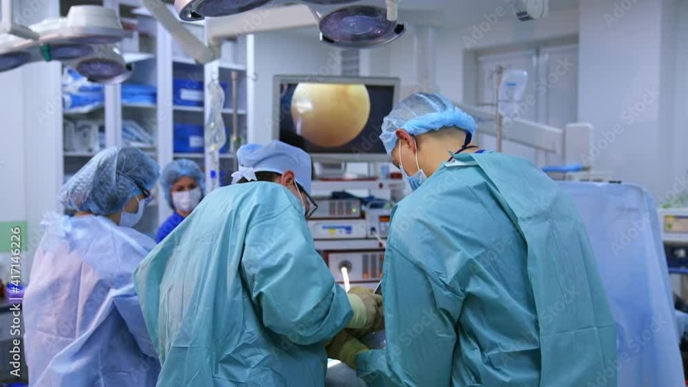Team of surgeons in the operating room. Operation in the modern medical cabinet. Professional doctors and nurses conduct an operation to a patient in surgical department. Team of surgeons in the operating room. Operation in the modern medical cabinet. Professional doctors and nurses conduct an operation to a patient in surgical department.