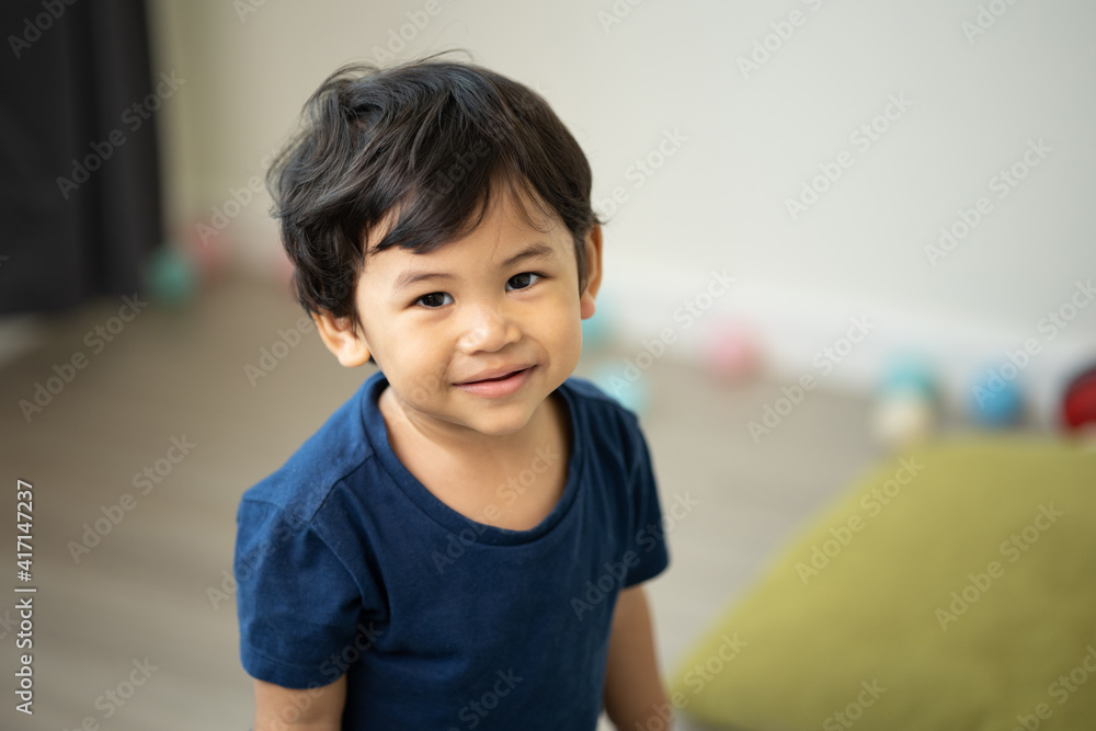 An Asian boy about 1 year old. Play in the living room of the house. He is wearing a blue shirt. An Asian boy about 1 year old. Play in the living room of the house. He is wearing a blue shirt.