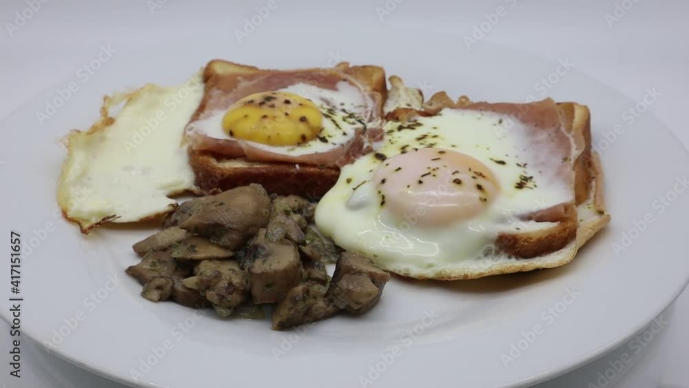 Eggs with ham, cheese, bread and mushrooms on a white rotating dish
Eggs with ham, cheese, bread and mushrooms on a white rotating dish