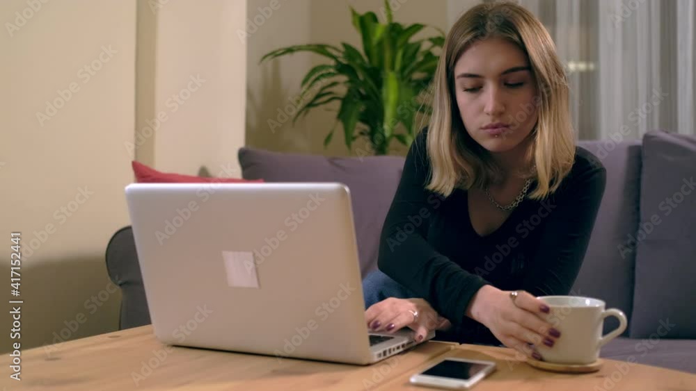 Turkish young woman working or studying at home with a computer on the table with a coffee cup Turkish young woman working or studying at home with a computer on the table with a coffee cup