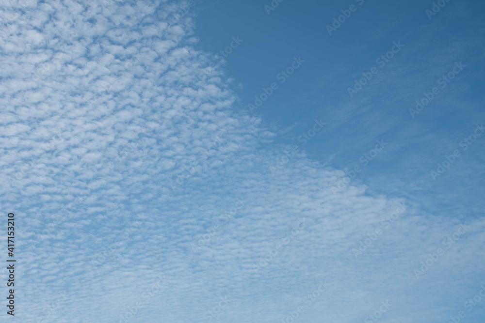 Fresh blue sky and soft white clouds, clean on a hot summer day. There is a copy space to put the design or text in the right of the image. The concept for the feeling of fresh weather.