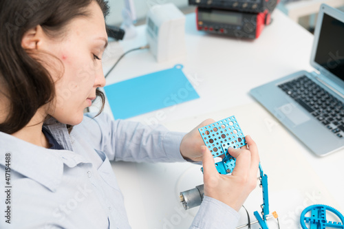 Student woman in robotics laboratory working on project mechatronics