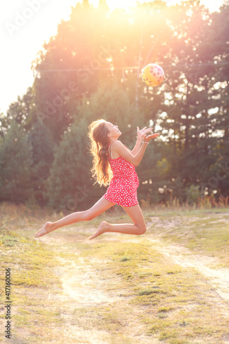 Portrait of Beautiful teenager girl  Is jumping and playing with ball at  summer sunset. Soft focused © katya_naumova