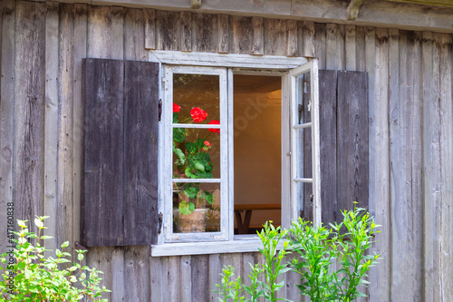 Old window in aged wooden house. Wooden wall from boards