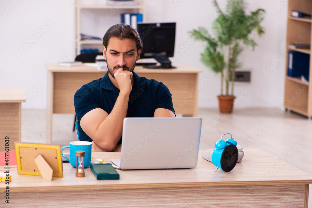 Young male employee working at workplace
