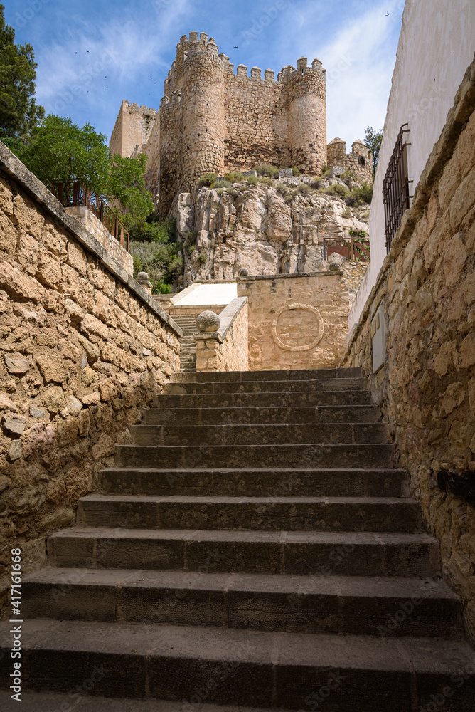 Stone stairs leading to the medieval castle placed on the top of hill above the historic town of Almansa on a sunny summer day, Albacete, Spain