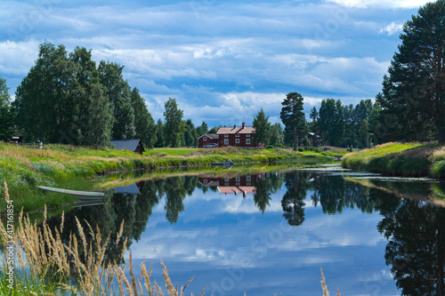 Landscape with a red house and a lake in Malung, Dalarna, Sweden photo