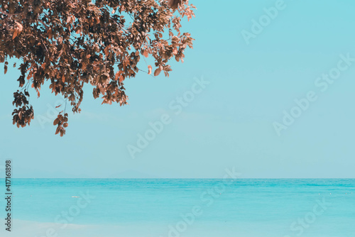 Fototapeta Naklejka Na Ścianę i Meble -  Vintage and retro toning of tropical beach with blue sky and clear sea which including of a wooden umbrella and chair in sunrise time with vintage retro tone. Vacation time as concept.	
