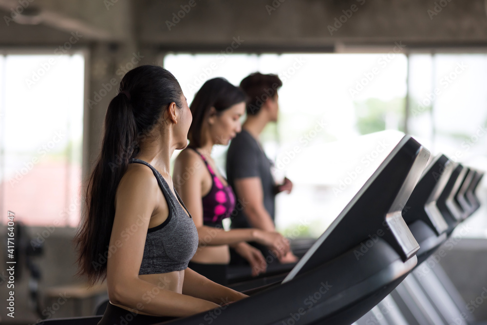 woman run and talk with friends on treadmills in gym woman run and talk with friends on treadmills in gym