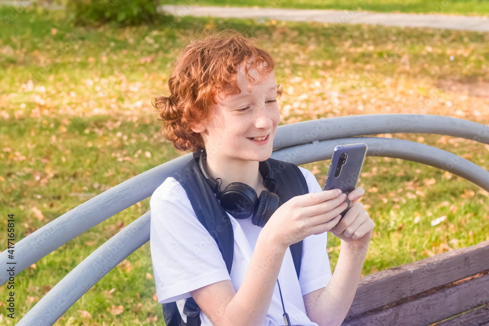 Teenager 11-13  with a smartphone in the park