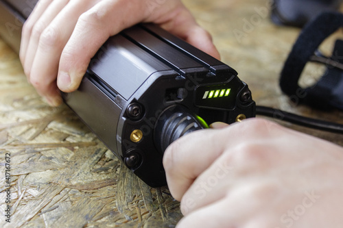 Electric bicycle battery charging process. Plugging in the charger.